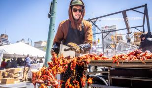 man pushes crawfish into bucket