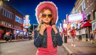 Girl with a pink cowboy hat on Beale Street.