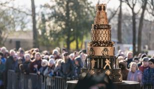 elvis 90th birthday cake on display in front of crowd at graceland lawn