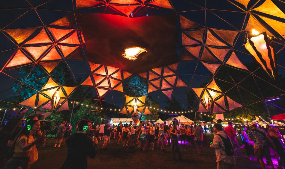 The Incendia Dome at Mempho Music Fest glows at night, crowds dancing within it.