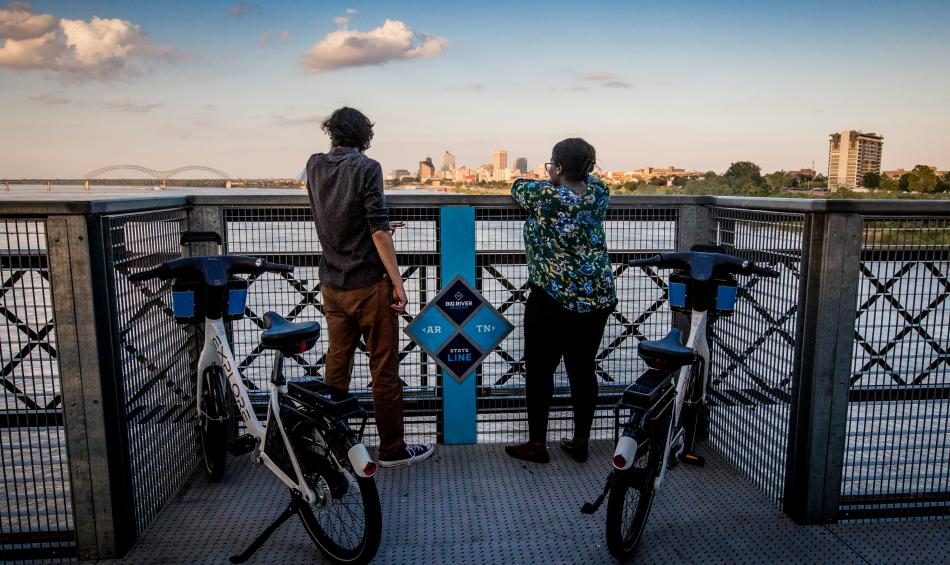 two bikers stop to view the memphis skyline from big river crossing