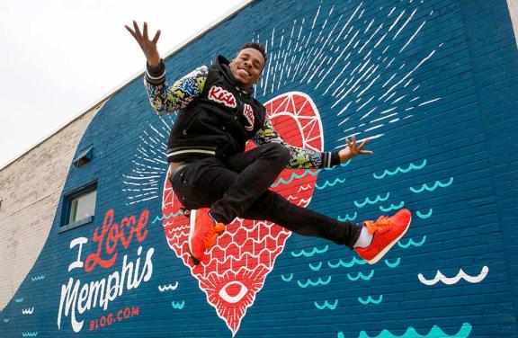 Lil Buck dancing in front of the I Love Memphis mural near Crosstown Concourse