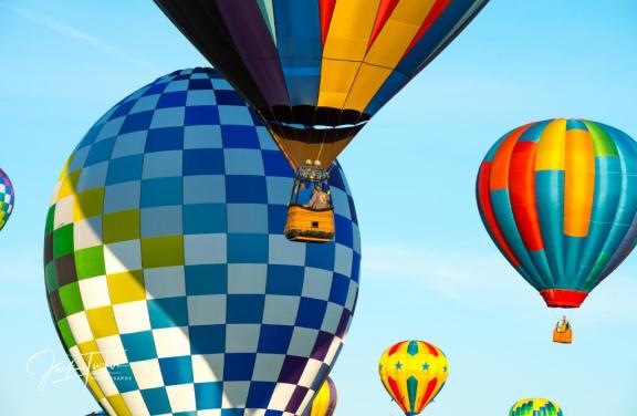 colorful hot air balloons floating through blue sky