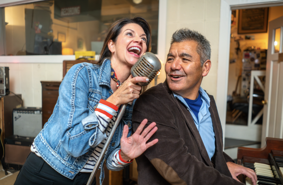 couple singing at sun studio into elvis mic