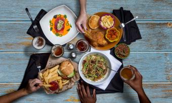 Hands reaching for food on a table