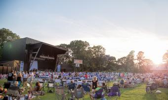 crowd of people on grassy lawn at Botanic Garden with music stage