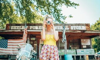 Girl snapping a photo in front of Shelby Forest General Store in Millington near Memphis | Oui We Girl