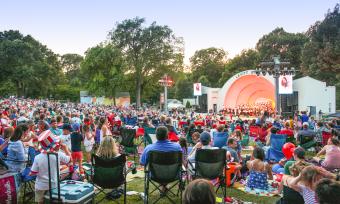 Hundreds of people sitting in lawn chairs in front of overton park shell stage