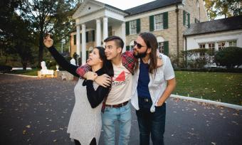 three people pose for photo outside of graceland house