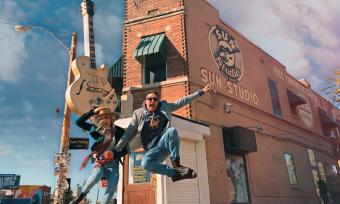 two people jump in the air in front of sun studio