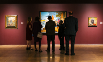 A group of visitors looking at a painting at the Brooks Museum of Art.